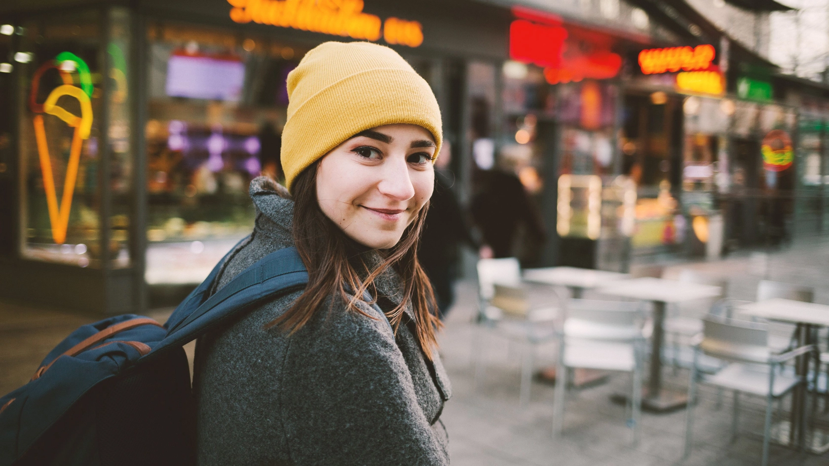 Junge Frau flaniert durch eine Einkaufsstraße