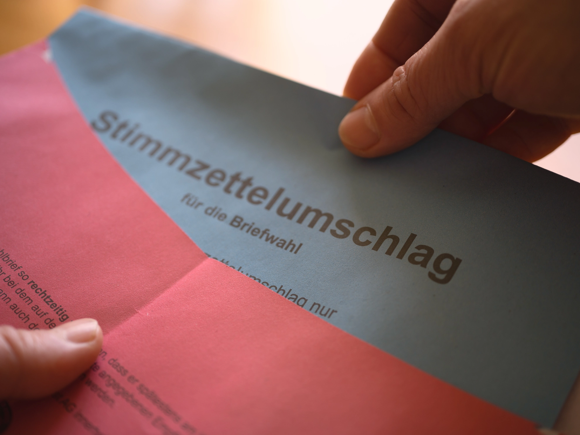 Nahaufnahme der Hände beim Schließen des Briefwahlumschlags